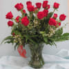 Two dozen red roses arranged in a traditional vase style with a