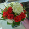 Medium size cube filled with 12 red Freedom roses, white hydrangea and