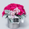 Hot pink, pink floyd roses with orchids in a modern silver vase.