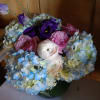 A beautiful floral arrangement of blue hydrangea, blush pink ranunculus, pink spray