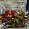 Red designed casket spray with a hint of other blooms and colors.