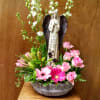 This arrangement is designed in a designer wicker container.  The angel