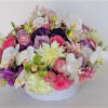 A lush arrangement in ceramic container, pastel with a pop of a