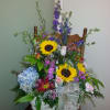 Colorful mix of garden flowers artfully arranged in a basket, styled 1-sided.