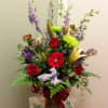 Tall garden mix with red Roses, purple Larkspur, Gerbera Daisys arranged artfully