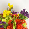 Vibrant color floral arrangement in the modern gold vase. Flowers may include