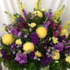 Bright yellow flowers with a pop of purple throughout this wicker basket