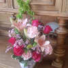 This beautiful floral arrangement contains lilies, roses, carnations and planter container that
