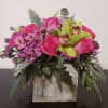 Composed of Roses, orchids, alstroemeria, variety of green.
