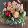 A mixture of dahlias, roses, wax flowers arranged with eucalyptus greens. 