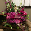 This arrangement includes a beautiful angel surrounded in a garden of pink
