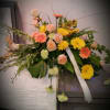 This contemporary styled spray feature peach roses , yelllow and peach gerbera