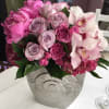 Peonies, lavender roses , pink hydrangea. orchids in a decorative metal container.