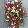 This tall red and white funeral spray comes complete with a standing