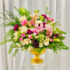Full display of pink and white flowers accented with winter greenery. 