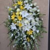 Standing spray including yellow and white flowers.