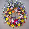 Standing wreath including all fresh flowers: iris, gerbera, rose, carnation, pompon... and