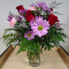 In a lovely vase, you have a beautiful arrangement with roses, carnations