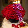 This arrangement is in a modern black ceramic vase that includes sixty