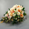 A cascading bridal bouquet of cream roses, white spray roses, peach roses