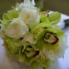 Vibrant green cymbidium orchids paired with cream and white roses and white