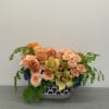 Cream toned arrangement with a blue and white vase 