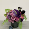 An arrangement with lisianthus, roses, orchids, and other flowers.
