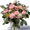 Soft and feminine arrangement of roses and wild flowers.