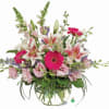 This bright bowl arrangement, filled with gentle blossoms in shades of pink