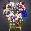 Sympathy heart-shaped spray with blue and white flowers.