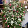 A standing spray consisting of medium pink roses, white dendrobium orchids and