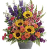 This bright arrangement includes orange roses, pink alstroemeria, hot pink carnations, yellow