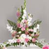 White Gladiolus cascade from a bouquet of Pink Snapdragons, Carnations and designer