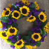 The wreath will be adorned with medium sized sunflowers, purple statice and