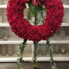 Large wreath composed of all red roses and an accent of exotic