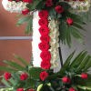 Beautiful large cross made of red roses, mums and other white fillers.