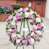 24&quot; wreath filled with roses and hydrangea.  Sympathy arrangements require more