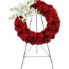 

A beautiful white cross made of daisies and carnation blooms is embellished