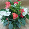 Vibrant red roses and carnations arranged in a clear cube vase along