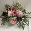 Elegant arrangement with pink garden roses, protea and fresh greens. Occasionally, substitutions