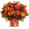 This radiant arrangement includes orange roses, light orange alstroemeria, purple button spray
