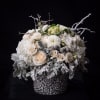 A holiday arrangement composed of hydrangeas, spray roses, white roses, ranunculus, flocked
