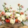 Fluffy romantic boat of luscious, seasonal blooms in pastels.