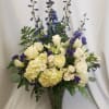 Classy and elegant arrangement with hydrangea, purple delphinium, and roses. 