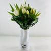 White tulips and luxurious greenery in a vase