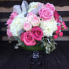 Hydrangeas, pink roses, dusty miller and seed eucalyptus arranged in a glass