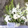 An all white basket arrangement of White Oriental Lillies, White Roses, White