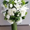 tall arrangement composed all white flowers such as hydrangeas, roses and lilies.
