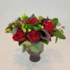 A lush vase arrangement of fresh seasonal blooms in deep red, purple