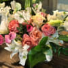 Bursts of casablanca lilies, ranunculus, sweet peas, roses with touch of greenery